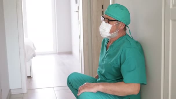 Hastanede duvara yaslanan yorgun doktor. — Stok video