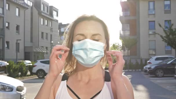 Portret kobiety z przyjemnością zdejmującej maskę medyczną. Wiosna w mieście. — Wideo stockowe