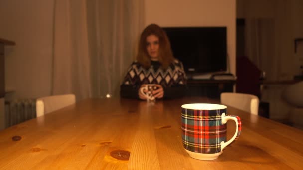 Een jonge, mooie vrouw koffie of thee drinken in het comfort van uw huis 4k — Stockvideo