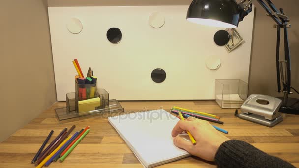 Buntstifte liegen auf dem Tisch. Männerhand nimmt den Bleistift und will auf die Oberfläche zeichnen 4k — Stockvideo