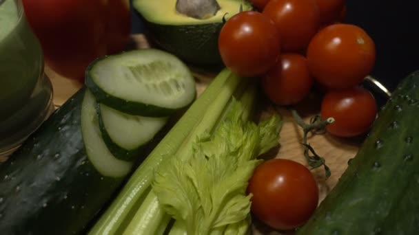 Verduras frescas y verduras en rodajas se encuentran en una mesa de madera. 4k — Vídeo de stock