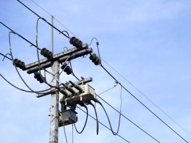 Elektrik direği bağlanmak için yüksek gerilim elektrik telleri mavi gökyüzü arka plan üzerinde.