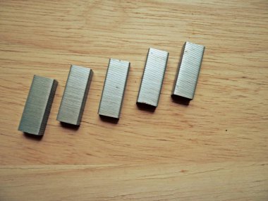 Ahşap arka planda metal Staples yığını