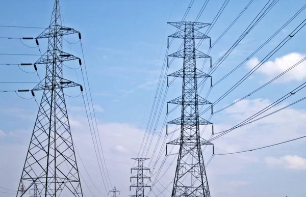 Gökyüzü arka planda yüksek voltaj elektrik kabloları