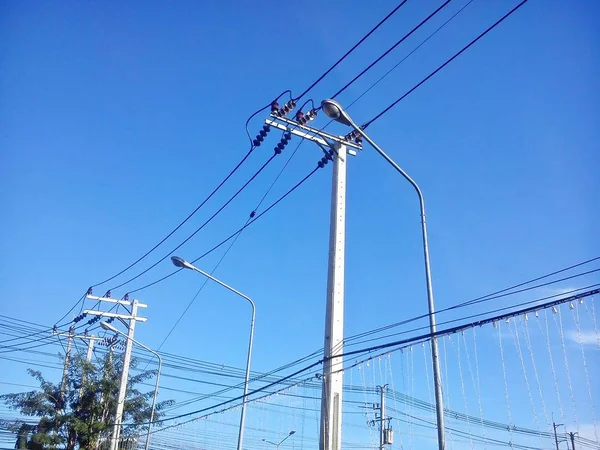 Elektrische paal verbinden met de hoogspanning elektrische draden op blauwe hemelachtergrond — Stockfoto