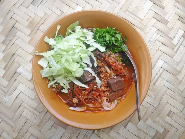 Rijst noedels met varkensvlees pikante saus (Thaise Kanom Jeen Nam Ngeaw) op de mandenmakerij bamboe — Stockfoto