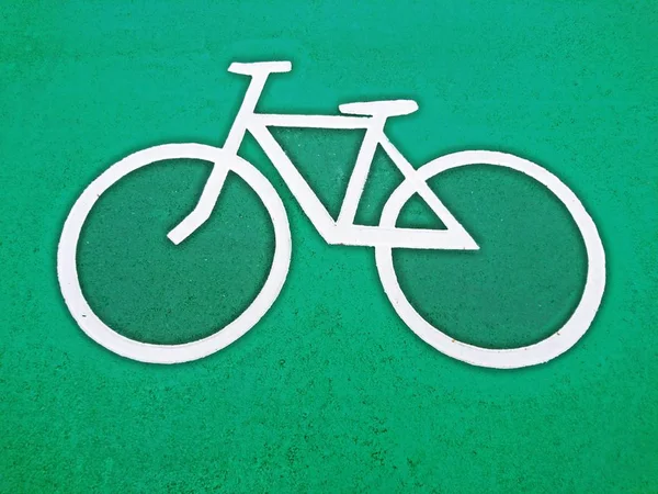 Bicycle lane signs white color on green color background in public park — Stock Photo, Image