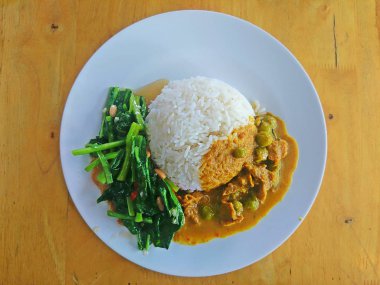 Hindistan cevizi sütü köri ile pirinç ve ahşap arka planda Kızarmış Sebzeler karıştırın