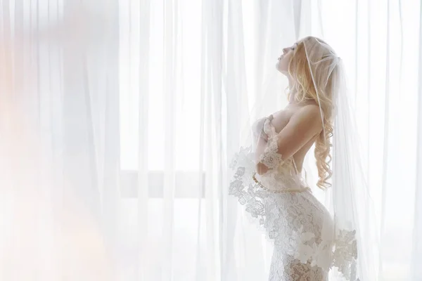 Mooie ochtend bruid in lingerie en witte jurk — Stockfoto