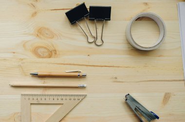 Ahşap kalem, kalem, üçgen, briefpapier klipleri, gün ışığında masaya hefter. Ofis Masaları