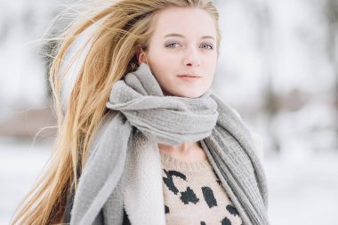 Sokakta poz güzel mutlu gülümseyen kız. Yüz dokunmadan uzun saçları ile oynarken modeli. Şık giysiler giyen kadın. Kış tatil kavramı. Sihirli kar yağışı etkisi