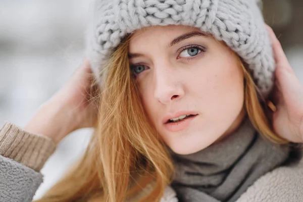 Junge schöne glücklich lächelnde Mädchen posiert auf der Straße. Model spielt mit ihren langen Haaren, berührt Gesicht. Frau in stylischer Kleidung. Winterferienkonzept. Magischer Schneefall-Effekt — Stockfoto