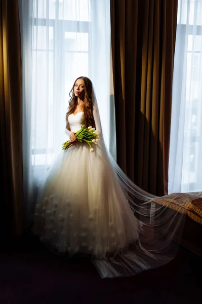 Noiva em vestido de noiva em suítes luxuosas. Noiva em um apartamento de luxo em um vestido de noiva . — Fotografia de Stock