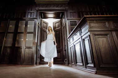 Genç güzel kız portresi kapalı yaz. Fairytale kapı ahşap dolap, izleri eski kale içinde yanında poz güzel kadın. Gelin beyaz atlas elbiseli. Fotoğraf bir model vardır.