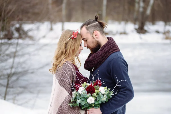 スタイリッシュな美しい若いカップル冬風景川の背景の上に立って新郎新婦. — ストック写真