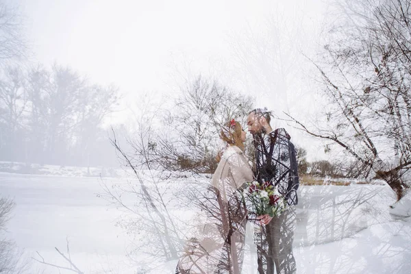 Elegante bela noiva casal jovem e noivo de pé no fundo de um rio paisagem de inverno. Exposição dupla — Fotografia de Stock