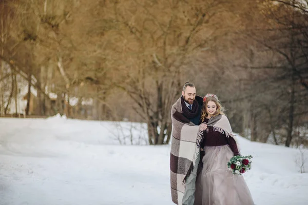 Stilvolle schöne junge Paar Braut und Bräutigam steht auf dem Hintergrund einer Winterlandschaft Fluss. — Stockfoto