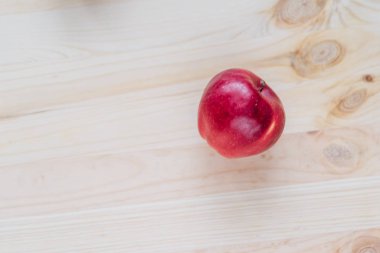 Ahşap güverte üzerinde taze kırmızı elma.