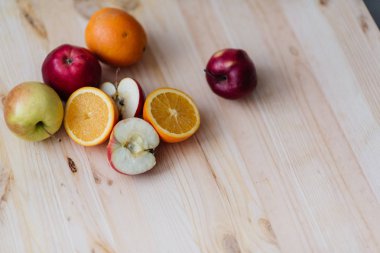 Taze kırmızı ve yeşil elma, ahşap güverte üzerinde turuncu.