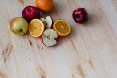 Taze kırmızı ve yeşil elma, ahşap güverte üzerinde turuncu.