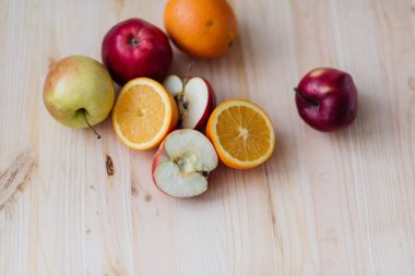 Taze kırmızı ve yeşil elma, ahşap güverte üzerinde turuncu.