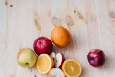 Taze kırmızı ve yeşil elma, ahşap güverte üzerinde turuncu.