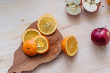 Taze kırmızı ve yeşil elma, ahşap güverte üzerinde turuncu.