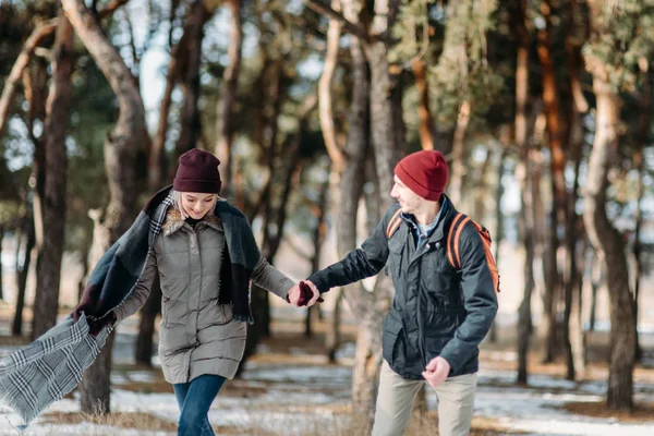 Young hipster couple hugging each other in winter park.