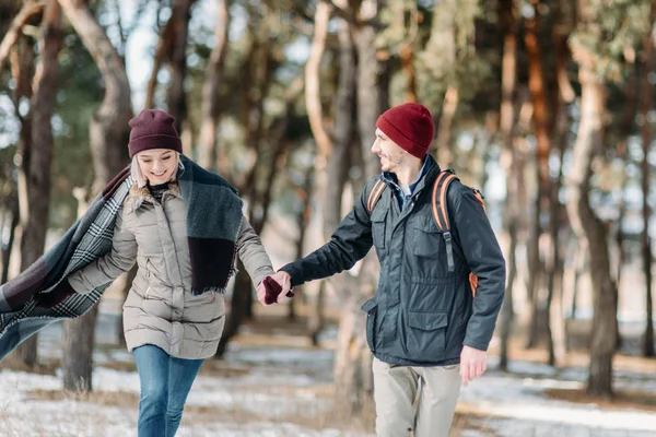 Young hipster couple hugging each other in winter park.