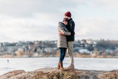 Genç hippi çift birbirlerine kış parkta sarılma.