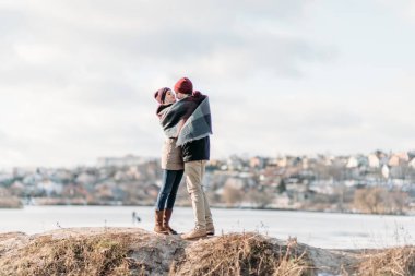 Genç hippi çift birbirlerine kış parkta sarılma.