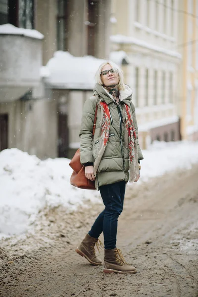 Kültéri álló fiatal szép boldog lány pózol utcában. Modell, elegáns meleg ruhát visel. Magic havazás. Téli ünnepek koncepció. Városi életmód. Derék fel. Szín — Stock Fotó