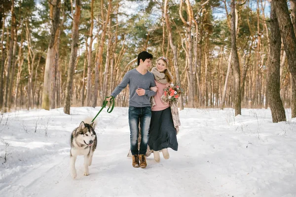 Utomhus lyckliga par i kärlek poserar med hund i kalla vintervädret. Ung pojke och flicka ha kul utomhus. Boho — Stockfoto