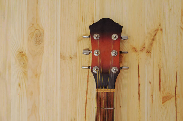 Acoustic guitar on wood desk background. Color