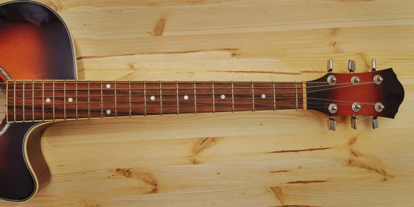 나무 책상 배경에 어쿠스틱 기타 — 스톡 사진