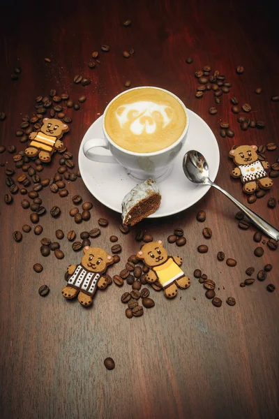 Humor vintage, capuchino en la parte superior con arte de latte de oso yacía en la mesa marrón, café con leche de amor . — Foto de Stock