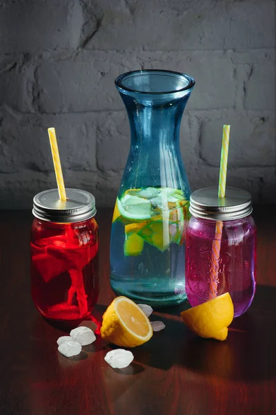 Бутылка лимонада с лимонами, лед на винтажном деревянном столе - натюрморт — стоковое фото