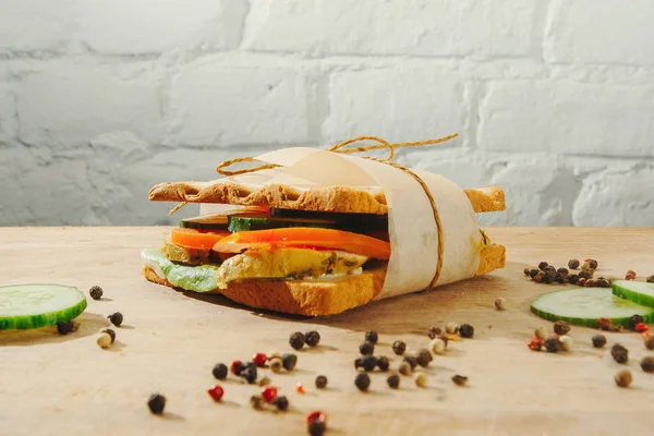 Nahaufnahme von Schinken und Gemüse - Tomaten, Gurken - auf Vollkornbrot. — Stockfoto