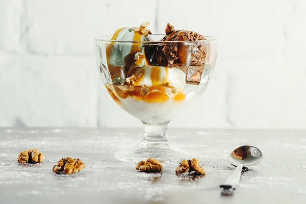 Домашнє шоколадне морозиво з арахісовим маслом, посипати подрібненим арахісом у скляній мисці на дерев'яному столі . — стокове фото