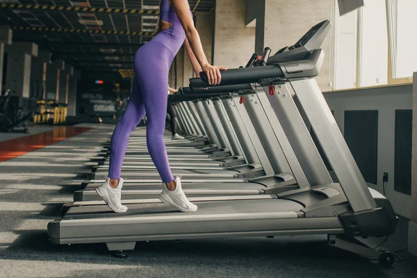 Ben av kvinna kör motion på löpbandet i gymmet som runn — Stockfoto