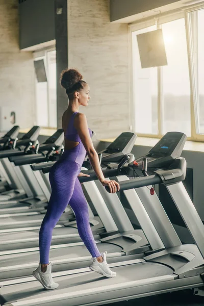 Flicka kör på löpbandet på gymmet, mjuk fokus bild — Stockfoto