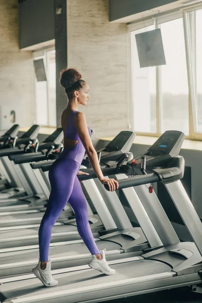 Slim atleta menina, correndo em uma esteira e trens no ginásio. Conceito de esportes, queima de gordura e um estilo de vida saudável . — Fotografia de Stock