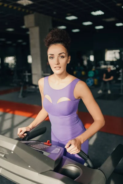 Young fitness woman doing cardio exercises at the gym. Girl runn