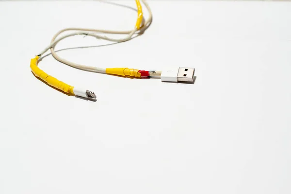 Un cable de carga está dañado sobre fondo blanco — Foto de Stock