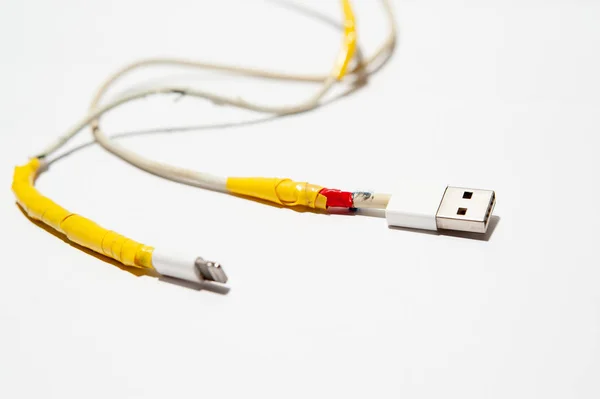 A charging cable is damaged on white background — Stock Photo, Image