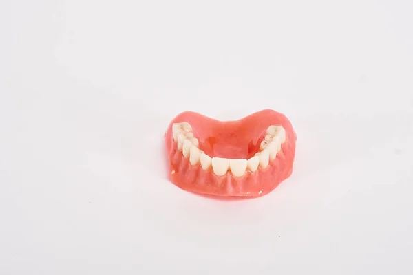 偽の売春婦歯科衛生士の検査の概念 上顎の完全な取り外し可能なプラスチック製の入れ歯 — ストック写真
