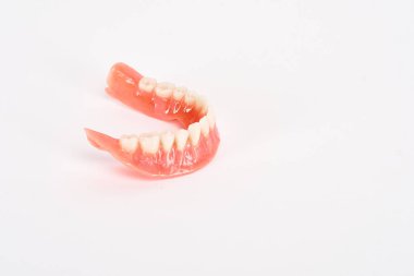 Sahte protezler. Diş hijyenisti konsepti. Alt çenenin tam çıkarılabilir plastik protezi.