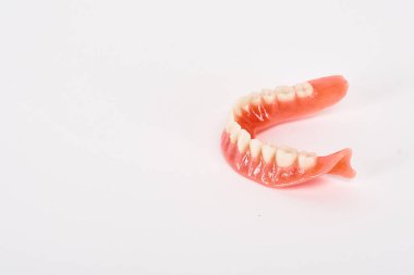 Sahte protezler. Diş hijyenisti konsepti. Alt çenenin tam çıkarılabilir plastik protezi.