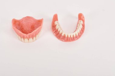 Sahte protezler. Diş hijyenisti konsepti. Alt çenenin tam çıkarılabilir plastik protezi.