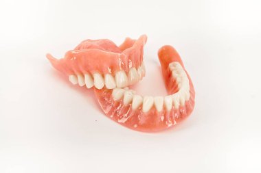 Sahte protezler. Diş hijyenisti konsepti. Alt çenenin tam çıkarılabilir plastik protezi.